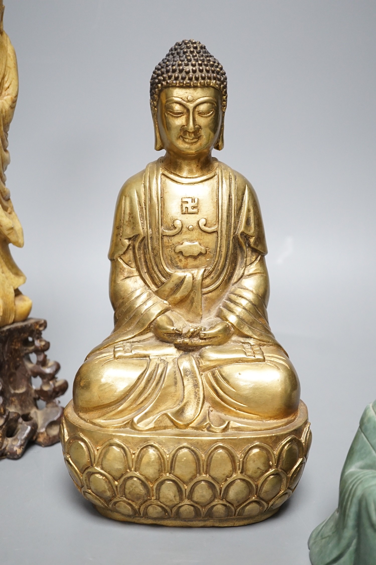 A Chinese greenstone Buddha, a soapstone carving of Shou Lao on carved hardwood stand, and a bronze figure of a seated Shaykamuni Buddha, tallest 29cm